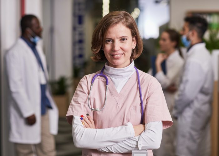 Young happy female general practitioner or nurse in medical scrubs